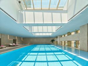 een groot zwembad met een glazen plafond bij DoubleTree by Hilton Qidong in Qidong