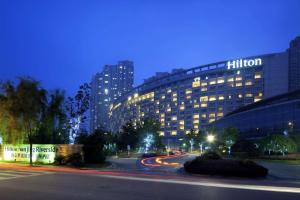 a building on a city street at night at Hilton Nanjing Riverside in Nanjing