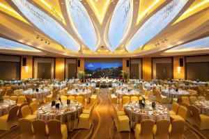een balzaal met tafels en stoelen en een groot plafond bij Hilton Nanjing Riverside in Nanjing
