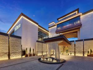 a building with a fountain in front of it at Hilton Shigatse in Shigatse