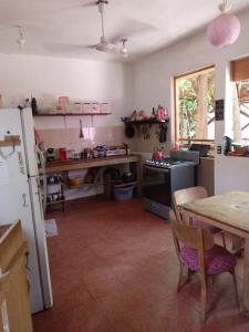 cocina con mesa, mesa y nevera en Hostal Caparazona, en Puerto Escondido