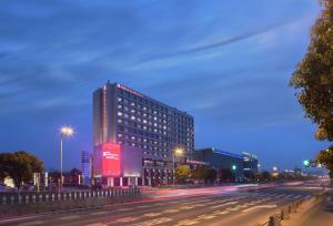 Un palazzo alto in una strada di città di notte di Hilton Garden Inn Shanghai Hongqiao NECC a Shanghai