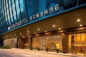 un edificio con un cartel en el costado en DoubleTree by Hilton Shenyang en Shenyang