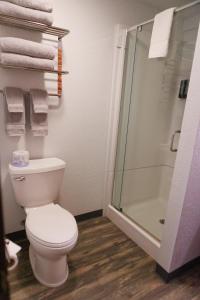 a bathroom with a toilet and a shower and towels at Creekside Cabins in Saint Ignatius
