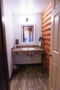 een badkamer met een wastafel en een spiegel bij Creekside Cabins in Saint Ignatius