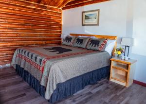 a bedroom with a bed and a wooden wall at Big Medicine Cabins in Saint Ignatius +9 photos