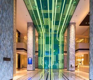 Hilton Garden Inn Xi'an High-Tech Zone في شيان: لوبي مبنى بجدار زجاجي