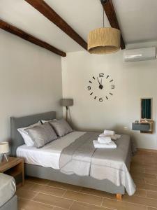 a bedroom with a bed with a clock on the wall at Giasemi apartments in Karistos