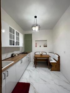 una cocina con armarios blancos y una mesa. en apartment in poti, en Poti