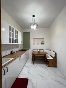 a kitchen with white cabinets and a table in it at poti apartment in Poti