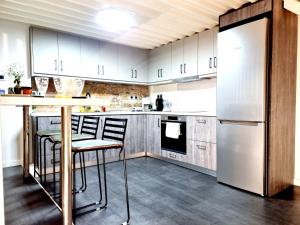 a kitchen with white cabinets and a table and a refrigerator at Castle luxury home in Chios