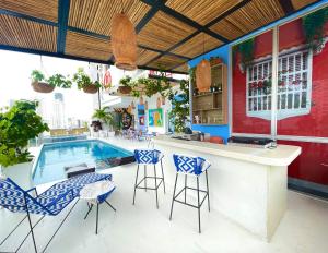 an outdoor bar with chairs and a swimming pool at Hotel Zi One Luxury in Cartagena de Indias