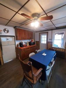cocina con mesa azul con sillas y ventilador de techo en Cozy Old House in Lost Creek PA: Enchanting Deck and Expansive Yard. 
