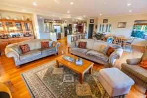 a living room with couches and a coffee table at Heaven's Rest B&B in Pukekohe East