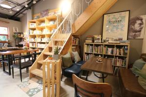 a library with a staircase and tables and bookshelves at 微光書旅-輕旅 in Tongluo