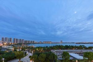 een skyline van de stad met een brug over een waterlichaam bij Hilton Suzhou Yinshan Lake in Suzhou