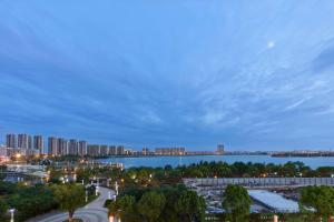 a city skyline with a bridge over a body of water at Hilton Suzhou Yinshan Lake in Suzhou
