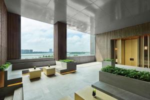 a lobby of a building with benches and plants at Hilton Suzhou Yinshan Lake in Suzhou