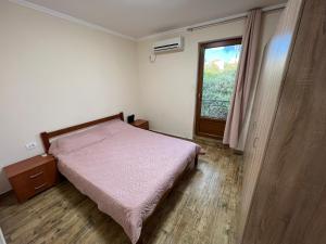 een kleine slaapkamer met een bed en een raam bij Apartment Sea View Dobra Voda in Dobra Voda