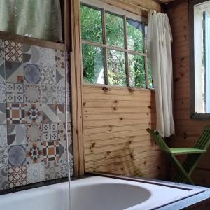 a bathroom with a tub and a window at Aldea Zen Chales Privativos in Ouro Preto