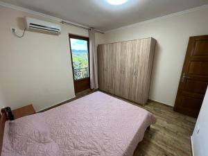 een slaapkamer met een roze bed en een raam bij Apartment Sea View Dobra Voda in Dobra Voda