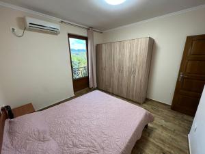 1 dormitorio con cama rosa y ventana en Apartment Sea View Dobra Voda, en Dobra Voda