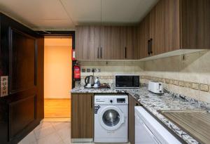 a kitchen with a washing machine on a counter at Saray Musheireb Hotel Suites and Apartment in Doha