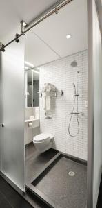 a white bathroom with a toilet and a shower at Pod Times Square in New York