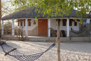 a house with a hammock in front of it at Bazouk Du Saloum Ecolodge Solidaire in Mar Lodj