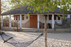 a house with a hammock in front of it at Bazouk Du Saloum Ecolodge in Mar Lodj