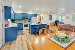 uma cozinha e sala de estar com armários azuis e uma mesa em Waterfront Spirit Lake Vacation Rental with Dock! em Spirit Lake