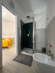a bathroom with a shower and a tub and a sink at Domu Dina Affittacamere 1 in Tertenìa