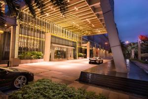 un edificio con un coche aparcado delante de él en Hilton Shenzhen Futian, Metro Station at Hotel Front Door, Close to Futian Convention & Exhibition Center, en Shenzhen