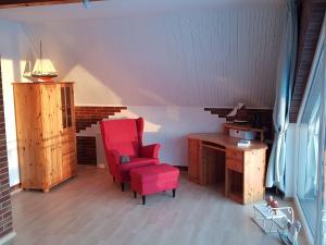 - un salon avec une chaise rouge et un bureau dans l'établissement Holiday home Inselperle, Putbus, à Wreechen