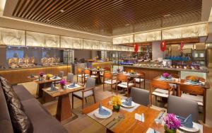 a restaurant with tables and chairs and a bar at DoubleTree by Hilton Hotel Qingdao-Jimo Ancient City in Jimo