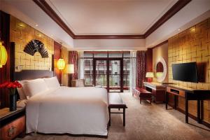 een slaapkamer met een groot wit bed en een televisie bij Hilton Tianjin Eco-City in Binhai