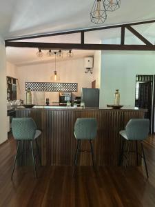 a kitchen with two chairs and a bar in a room at Villa REYDISIA in Saint-Laurent du Maroni