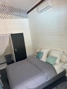 ein Schlafzimmer mit einem großen Bett mit weißen und blauen Kissen in der Unterkunft Villa REYDISIA in Saint-Laurent du Maroni
