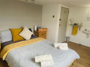 愛丁堡的住宿－Cosy loft room in Morningside, Edinburgh，一间卧室配有一张床,上面有两条毛巾