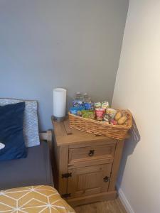 um cesto de comida numa mesa ao lado de uma cama em Cosy loft room in Morningside, Edinburgh em Edimburgo