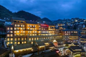 una città illuminata di notte con edifici di Hilton Garden Inn Guizhou Maotai Town a Maotai