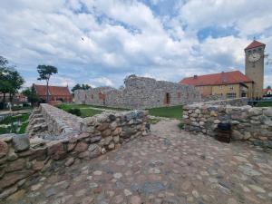 een stenen muur en een gebouw met een klokkentoren bij Mieszkanie 200m od jeziora in Szczytno