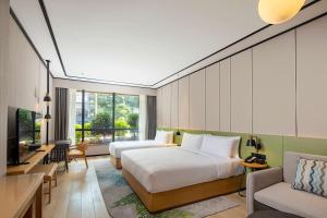 une chambre d'hôtel avec deux lits et un salon dans l'établissement Hilton Garden Inn Guizhou Maotai Town, à Maotai
