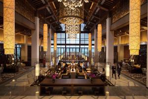 a large lobby with a chandelier in a building at Hilton Wuhan Optics Valley in Wuhan