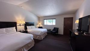 um quarto de hotel com duas camas e uma televisão de ecrã plano em The Shelby Inn em Shelbyville