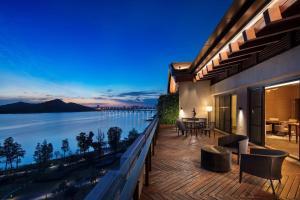 a house with a balcony with a view of the water at Hilton Wuhan Optics Valley in Wuhan