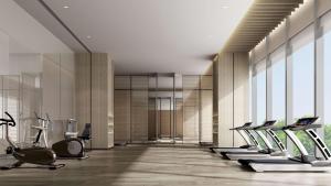 a gym with a row of treadmills and ellipticals at Doubletree By Hilton Xian Fengdong in Xi'an