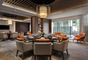 uma sala de jantar com uma grande mesa e cadeiras em Canopy by Hilton Xi'an Qujiang em Xi'an