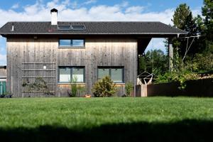 una casa de madera con césped delante en Ferienhaus Bergblick Bregenzerwald en Bregenz