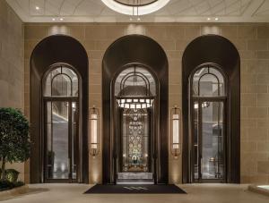 een lobby met drie gewelfde deuren en een kroonluchter bij Waldorf Astoria Xiamen in Xiamen